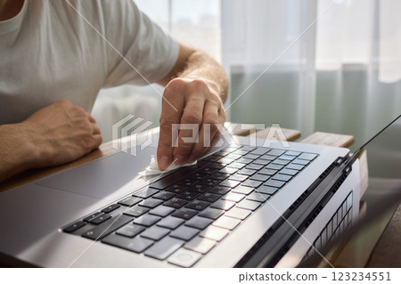 Meticulously Hand Cleaning Your Laptop with a Tissue to Achieve a Fresh and Neat Workspace Meticulously Hand Cleaning Your Laptop with a Tissue to Achieve a Fresh and Neat Workspace 123234551