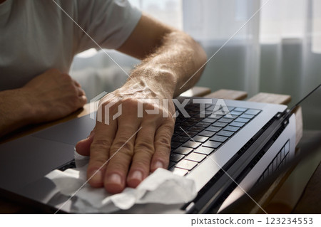 Meticulously Hand Cleaning Your Laptop with a Tissue to Achieve a Fresh and Neat Workspace 123234553