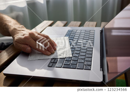 Meticulously Hand Cleaning Your Laptop with a Tissue to Achieve a Fresh and Neat Workspace Meticulously Hand Cleaning Your Laptop with a Tissue to Achieve a Fresh and Neat Workspace 123234566