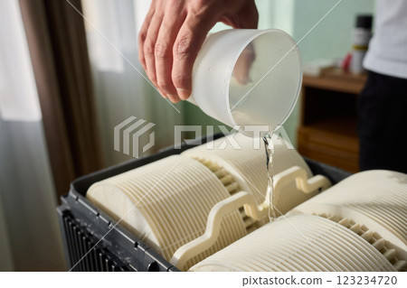 Pouring liquid into a storage container daily improves organization and efficiency 123234720