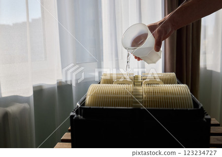 Pouring liquid into a storage container daily improves organization and efficiency 123234727