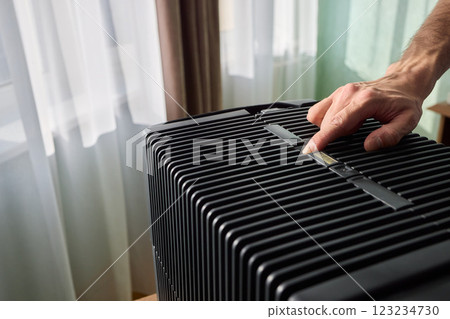Hands adjusting a modern appliances control panel for optimal functionality and home comfort Hands adjusting a modern appliances control panel for optimal functionality and home comfort 123234730