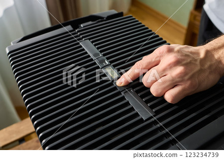 Hands adjusting a modern appliances control panel for optimal functionality and home comfort Hands adjusting a modern appliances control panel for optimal functionality and home comfort 123234739
