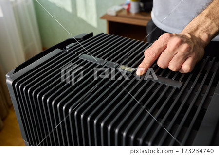 Hands adjusting a modern appliances control panel for optimal functionality and home comfort Hands adjusting a modern appliances control panel for optimal functionality and home comfort 123234740