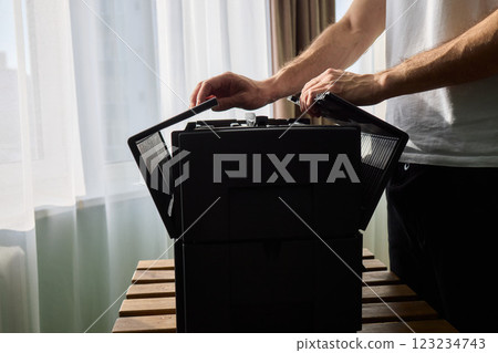 A person diligently assembling a contemporary black cooling device with precision and focus 123234743