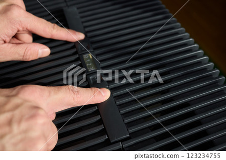 Hands adjusting a modern appliances control panel for optimal functionality and home comfort Hands adjusting a modern appliances control panel for optimal functionality and home comfort 123234755