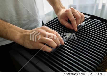 Hands adjusting a modern appliances control panel for optimal functionality and home comfort Hands adjusting a modern appliances control panel for optimal functionality and home comfort 123234760