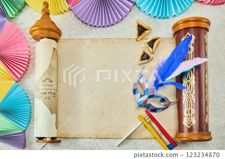 Purim Celebration Items. Festive Purim setup with Esther scrolls, Hamantaschen, and a mask 123234870