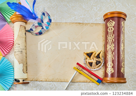 Purim Celebration Items. Festive Purim setup with Esther scrolls, Hamantaschen, and a mask 123234884
