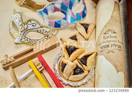 Purim Celebration Items. Festive Purim setup with Esther scrolls, Hamantaschen, and a mask Purim Celebration Items. Festive Purim setup with Esther scrolls, Hamantaschen, and a mask 123234890