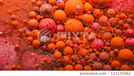 Mystic flow. Acryl bubble. Orange pink red shimmering swirling foam oil emulsion texture. Colorful ink drops in water abstract background. 123235062