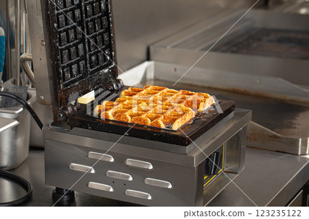 Cooking belgian waffles in the cafe kitchen 123235122