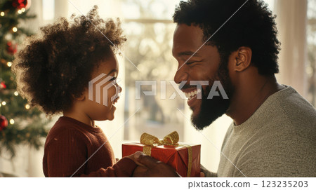 A father smiles warmly while holding a gift from his child in a cozy home environment. Perfect for Father's Day and family-themed content 123235203