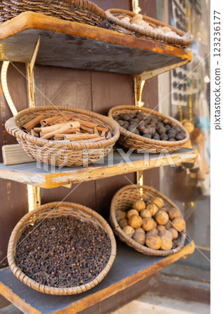 Traditional spices market. Pots and wooden tubs stand in row with tea, spices, fruits, roots, flowers. Street bazaar. Dubai, UAE. Vertical photo 123236177