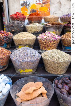 Traditional spices market. Pots and wooden tubs stand in row with colorful tea, spices, fruits, roots, flowers. Street bazaar. Dubai, UAE. Vertical photo 123236178