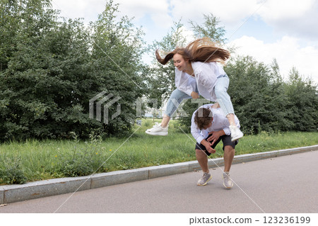 Loving couple of young girl and man are walking and having fun in park on warm summer day. High quality photo Loving couple of young girl and man are walking and having fun in park on warm summer day. High quality photo 123236199