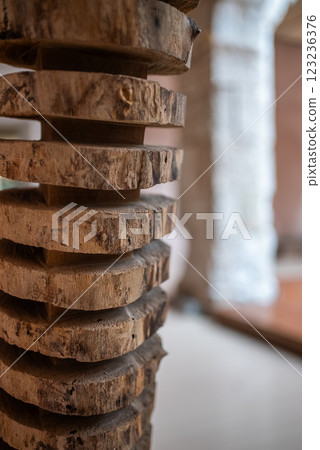 Close-up of stacked wooden slices reveals the natural patterns and textures on their surfaces, adding unique character to the contemporary interior space. Close-up of stacked wooden slices reveals the natural patterns and textures on their surfaces, adding unique character to the contemporary interior space. 123236376