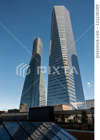 Modern tall skyscraper towers rise against clear blue sky in bustling urban business area during daylight hours, Cuatro Torres and downtown district of Madrid Modern tall skyscraper towers rise against clear blue sky in bustling urban business area during daylight hours, Cuatro Torres and downtown district of Madrid 123236389
