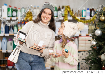 Woman with child family selects and studies label makeup cosmetic agent on New Year Eve Woman with child family selects and studies label makeup cosmetic agent on New Year Eve 123236419