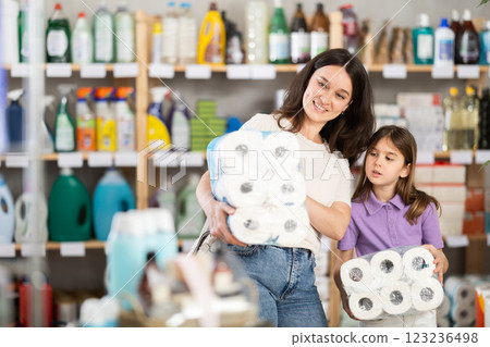 Little daughter and mother buy toilet paper together at supermarket 123236498