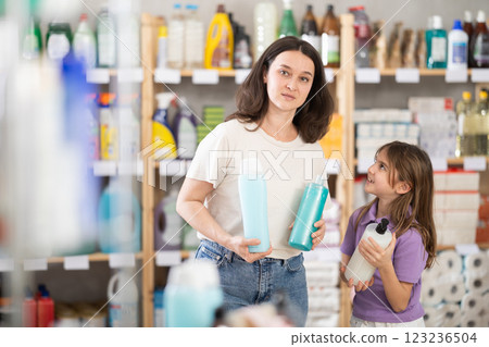 Woman with daughter choosing shampoo or shower gel 123236504