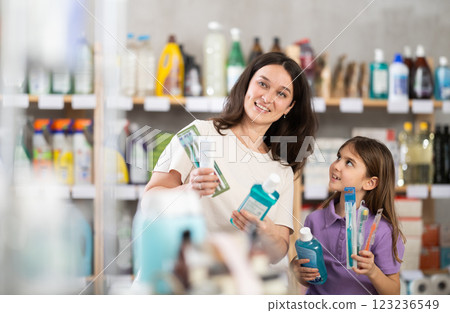 Woman with daughter choosing dental care products 123236549