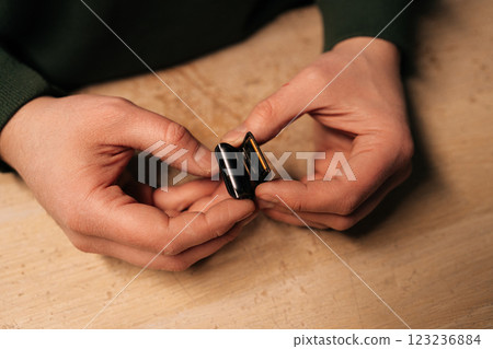Top view of technician carefully replacing battery of smartwatch using specialized tools, highlighting intricate process of modern device repair. Concept of process electronic device repair. 123236884