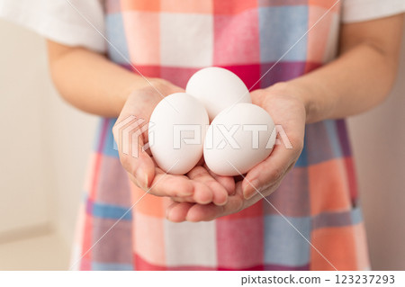 Image of a woman holding a raw egg (stock photo) Image of a woman holding a raw egg (stock photo) 123237293