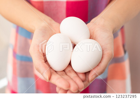 Image of a woman holding a raw egg (stock photo) Image of a woman holding a raw egg (stock photo) 123237295