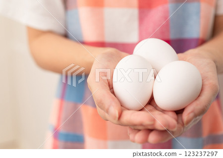 Image of a woman holding a raw egg (stock photo) Image of a woman holding a raw egg (stock photo) 123237297