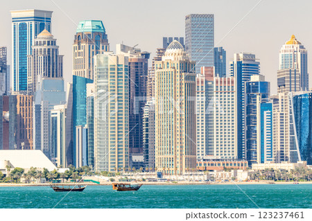Doha modern business downtown center skyscrapers shoreline with small traditional arab dhow fishermen boats at the sea bay, Qatar 123237461
