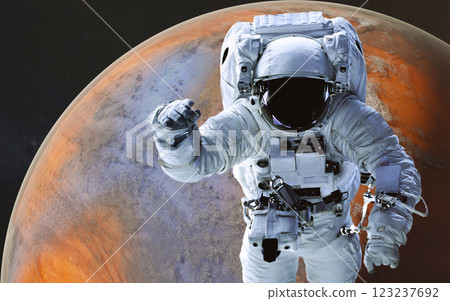Space astronaut in a white spacesuit floating in space during a spacewalk, in a front of red fiction planet with atmosphere visible below and a starry space background. Space astronaut in a white spacesuit floating in space during a spacewalk, in a front of red fiction planet with atmosphere visible below and a starry space background. 123237692