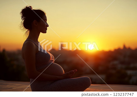Pregnant woman sitting outdoors at sunset, practicing meditation. Concept of calm and anticipation. For articles on pregnancy wellness 123237747