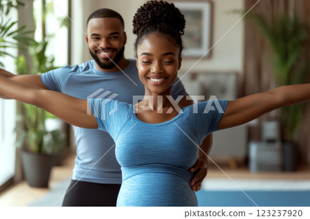A couple is doing a yoga pose together indoors, both smiling and looking relaxed. Concept of wellness and harmony. For fitness lifestyle promotion A couple is doing a yoga pose together indoors, both smiling and looking relaxed. Concept of wellness and harmony. For fitness lifestyle promotion 123237920