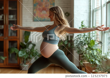 Pregnant woman in yoga pose indoors with plants around. Concept of wellness and prenatal fitness. For healthy lifestyle promotion 123237973