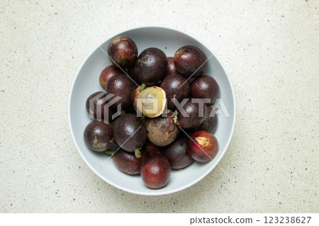 Matoa fruit (Pometia pinnata) typical of Papua Indonesia in a white bowl with a terrazzo granite background Matoa fruit (Pometia pinnata) typical of Papua Indonesia in a white bowl with a terrazzo granite background 123238627