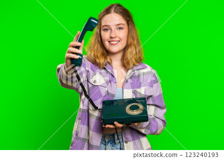 Young woman talking on wired landline vintage telephone, advertising proposition of conversation 123240193