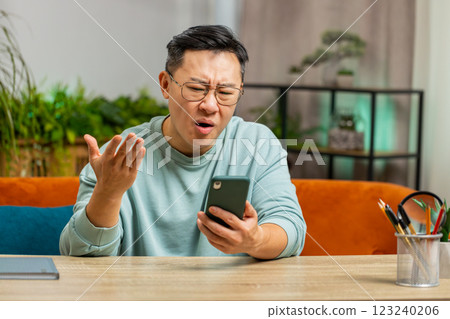 Sad Asian man use smartphone surprised by bad news, fortune loss, fail, lottery results, deadline Sad Asian man use smartphone surprised by bad news, fortune loss, fail, lottery results, deadline 123240206