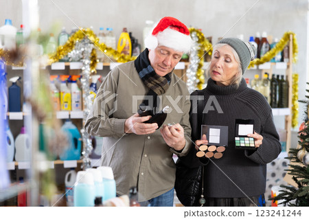 Elderly couple choosing cosmetics and perfume in supermarket before celebrating Christmas 123241244