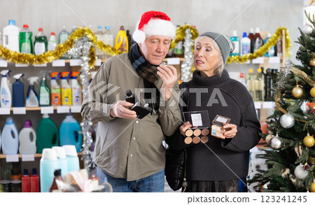 Elderly couple choosing cosmetics and perfume in supermarket before celebrating Christmas 123241245