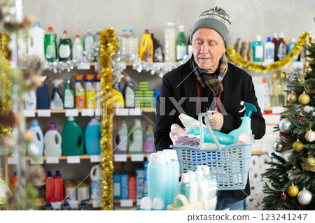 elderly man chooses household chemicals in a supermarket 123241247