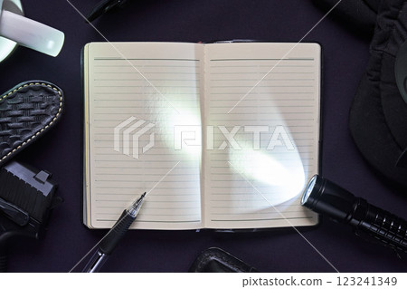 A flashlight and notebook on a navy blue uniform A flashlight and notebook on a navy blue uniform 123241349
