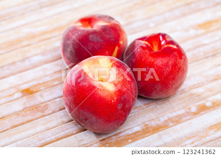 Closeup of whole ripe red peaches on wooden table. 123241362