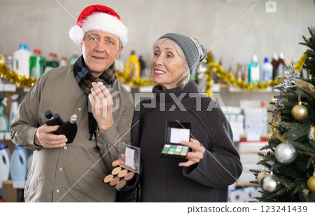Couple man and woman choosing perfume and cosmetics in decorated store Couple man and woman choosing perfume and cosmetics in decorated store 123241439
