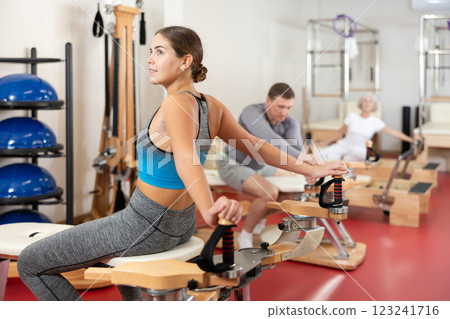 Girl performs Pilates exercises for weight loss and toning muscles of back and shoulders 123241716