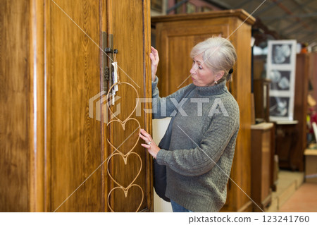 Senior woman choosing closet in furniture store Senior woman choosing closet in furniture store 123241760