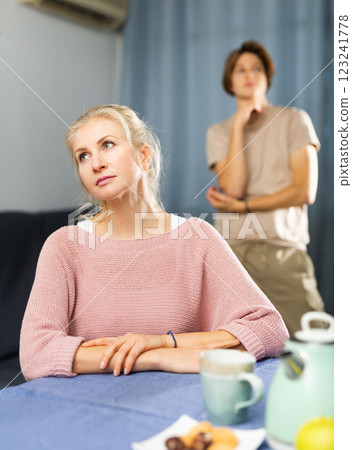 Upset woman sitting at home after disagreements with teenage son Upset woman sitting at home after disagreements with teenage son 123241778