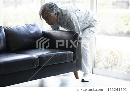 Senior man in work clothes carrying furniture 123241891