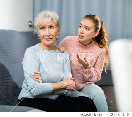 Adult daughter asking for forgiveness from upset elderly mother on sofa Adult daughter asking for forgiveness from upset elderly mother on sofa 123241930