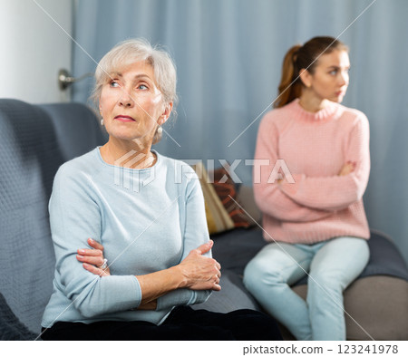 Offended elderly woman sitting on sofa after quarrel with daughter Offended elderly woman sitting on sofa after quarrel with daughter 123241978
